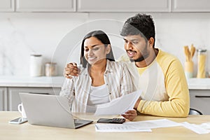 Couple engaging with finances on laptop at kicthen