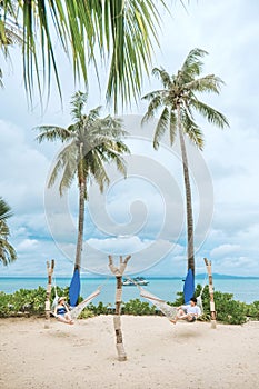 A couple enjoying a beach vacation at a tropical resort with a beautifully landscaped coastal pool at sunset. honeymoon