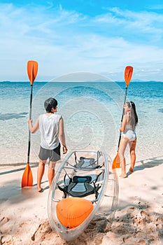 A couple enjoying a beach vacation at a tropical resort with a beautifully landscaped coastal pool at sunset. honeymoon