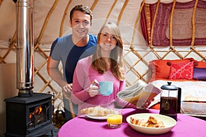 Couple Enjoying Breakfast Camping In Traditional Yurt