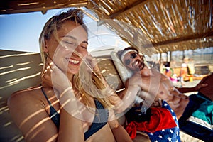 Couple enjoying day at beach. Man showing affection toward woman, caressing her hair. Summertime vacation. Holiday, fun, lesiure,