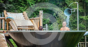 Couple enjoying a good bath in a unique jakuzzi at Hija Glamping Lake Block in Nova Vos, Slovenia photo