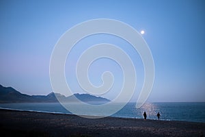 A couple enjoying the moon lit landscape. The environment is quiet and peaceful. This was taken in Kaikoura, New Zealand. Couple