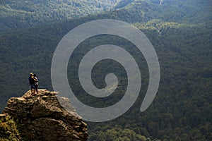 Couple Enjoying Mountain View on Rock Peak. Amazing Mountain Scenery