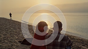 Couple enjoying ocean view at sunset. Lovers spending summer vacation on beach