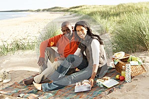 Couple Enjoying Picnic On Beach Together