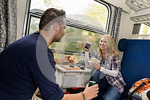 Couple enjoying sandwiches traveling with train