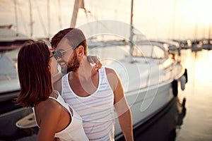 Couple enjoying by the sea.Woman kissing man on dock during sunset