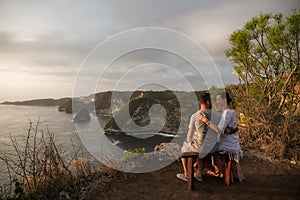 Couple enjoying view from Banah Cliff of Nusa Penida island, Indonesia