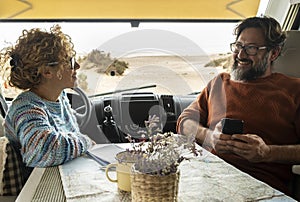 Couple enjoys the weekend aboard their camper. Happy man together with his wife spending pleasant moments. Concept of freedom and