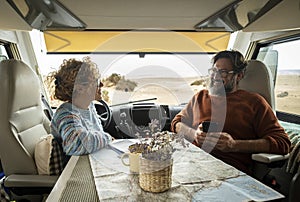 Couple enjoys the weekend aboard their camper. Happy man together with his wife spending pleasant moments. Concept of freedom and