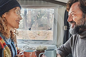 Couple enjoys the weekend aboard their camper. Happy man together with his wife spending pleasant moments. Concept of freedom and
