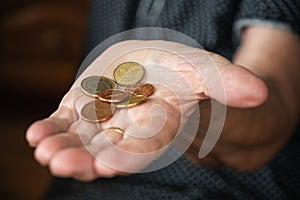 Couple of euro coins in elderly senior woman hand