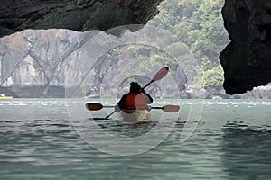 Couple exploring cave on kayak and taking photograps in the boat. Ha Long Bay, Vietnam, Cat Ba Island