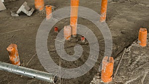 A couple of exposed pvc pipe endings jutting out from the concrete floor are in place for plumbing of a future lavatory