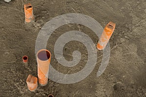 A couple of exposed pvc pipe endings jutting out from the concrete floor are in place for plumbing of a future restroom.