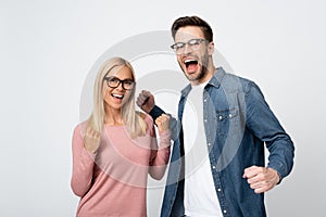 Couple in eyeglasses showing yeah gesture