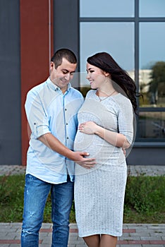 Couple family in the expectation of a baby hugging in the city