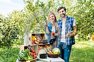 couple of farmers showing ripe vegetables at farmer