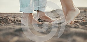 Couple feet kissing and loving concept. Outdoor leisure activity. Relationship boy and girl in summer at the beach. People