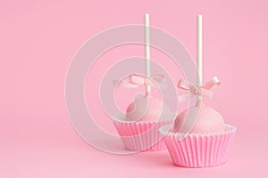 Couple festive icing cake pops over pink background, concept of