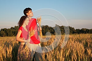 Couple in field with wheat in hands