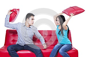 Couple fight on red sofa - isolated