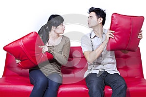 Couple fighting on red sofa - isolated