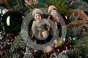 Couple of Figurines Sitting on Top of a Christmas Tree