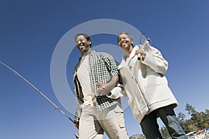 Couple on fishing trip, holding hand, smiling