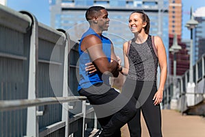 A couple of fitness friends of mixed American ethnicity, chatting and talking during a fitness jogging exercise in the city