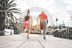 Couple of fitness friends running outside at sunset time - Sportive people training at evening sprinting outdoor - Jogging,