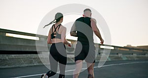 Couple, fitness and running in city for workout, outdoor exercise or training together in urban town. Rear view of