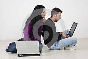 Couple on floor browsing internet on laptops