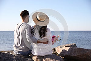 Couple with flowers at beach. Honeymoon trip