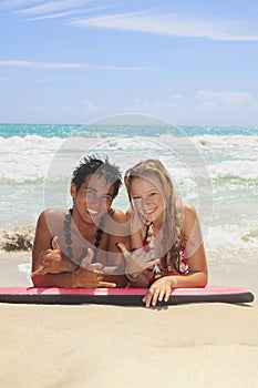 Couple on a foam surfboard at beach