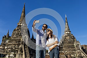 Couple of foreign tourists take selfie photo at Wat Phra Si Sanphet temple, Ayutthaya Thailand, for travel, vacation, holiday,