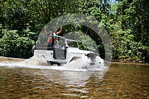 Couple, forest and adventure with 4x4, river and outdoor with love, care or nature with drive in summer. People, man and