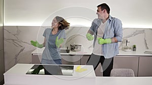 Couple with four hands cleaning cooktop cooking panel on kitchen. Young man and woman cleaning up the perfect surface of