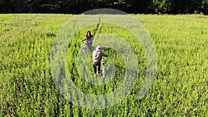 Couple of friends on bicycles meeting in the green field and shake hands, companion friedship concept, aerial shot from