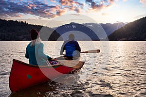 Couple friends canoeing on a wooden canoe