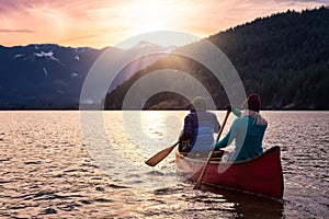 Couple friends canoeing on a wooden canoe