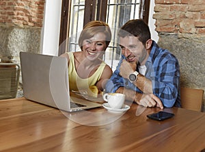 Couple or friends at coffee shop working with laptop computer in the morning happy