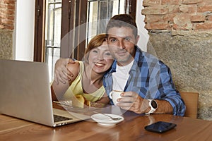 Couple or friends at coffee shop working with laptop computer in the morning happy