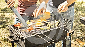 Couple of friends cooking vegetables on barbecue - Aubergines and peppers cooked on grill at bbq garden party - Pic nic concept
