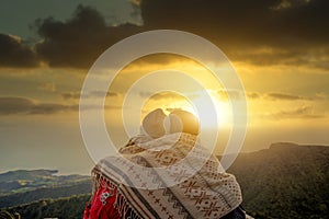 Couple of friends enjoying sunset on the top of the mountain