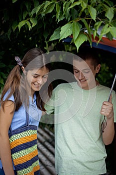 Couple of friends under umbrellas on a rainy day