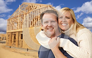 Couple in Front of New Home Construction Framing Site