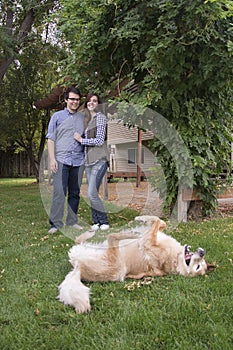 Couple in front of new home holding sold blackboard sign