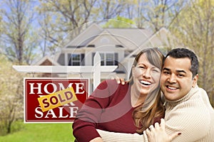 Couple in Front of Sold Real Estate Sign and House